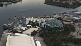 5.7K aerial stock footage fly away from and orbit a warship museum and aquarium in Tampa, Florida Aerial Stock Footage | DX0003_230_031