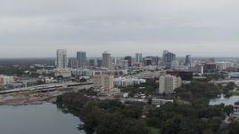 5.7K aerial stock footage of a reverse view of the city's skyline, seen from a lake, Downtown Orlando, Florida Aerial Stock Footage | DX0003_233_003