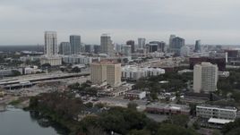 5.7K aerial stock footage of a reverse view of a hotel and the city's skyline, Downtown Orlando, Florida Aerial Stock Footage | DX0003_233_010
