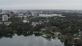 5.7K aerial stock footage descend toward lakeside park while focused on apartment buildings in Orlando, Florida Aerial Stock Footage | DX0003_233_020