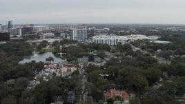 5.7K aerial stock footage descend toward lakeside park while focused on apartment buildings in Orlando, Florida Aerial Stock Footage | DX0003_233_021