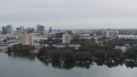 5.7K aerial stock footage of office building by a lake, city's skyline in the background, Downtown Orlando, Florida Aerial Stock Footage | DX0003_233_023