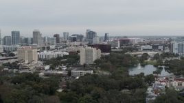 5.7K aerial stock footage ascend from lake toward office building and city's skyline, Downtown Orlando, Florida Aerial Stock Footage | DX0003_233_024