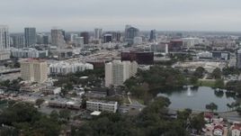 5.7K aerial stock footage flying away from lake, office building and city's skyline, Downtown Orlando, Florida Aerial Stock Footage | DX0003_233_025