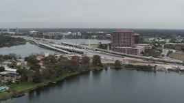 5.7K aerial stock footage of flying by light freeway traffic and office building by a lake in Orlando, Florida Aerial Stock Footage | DX0003_233_027
