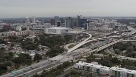 5.7K aerial stock footage of flying by Amway Center, city skyline beside freeway interchange, Downtown Orlando, Florida Aerial Stock Footage | DX0003_234_004