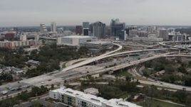 5.7K aerial stock footage descend past Amway Center, city skyline beside freeway interchange, Downtown Orlando, Florida Aerial Stock Footage | DX0003_234_005