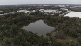 5.7K aerial stock footage a stationary view of a small lake and forest trees, Orlando, Florida Aerial Stock Footage | DX0003_234_056