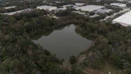 5.7K aerial stock footage ascend while focused on a small lake and forest trees, Orlando, Florida Aerial Stock Footage | DX0003_234_057