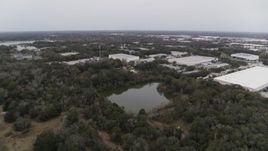 5.7K aerial stock footage fly away from a small lake and forest trees, Orlando, Florida Aerial Stock Footage | DX0003_234_058