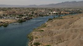 4K aerial stock footage follow the Colorado River to approach riverfront homes and apartments in Bullhead City, Arizona Aerial Stock Footage | FG0001_000010
