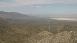 4K aerial stock footage fly over mountains in the Mojave Desert to reveal a desert valley in San Bernardino County, California Aerial Stock Footage | FG0001_000049