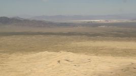 4K aerial stock footage of Mojave Desert mountains across a rugged plain in San Bernardino County, California Aerial Stock Footage | FG0001_000053