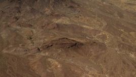4K aerial stock footage tilt from Mojave Desert hills to reveal mountains in San Bernardino County, California Aerial Stock Footage | FG0001_000077