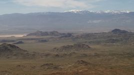 4K aerial stock footage of the San Bernardino Mountains with snow behind Mojave Desert mountains, San Bernardino County, California Aerial Stock Footage | FG0001_000114