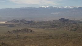 4K aerial stock footage of a view of the San Bernardino Mountains with snow from Mojave Desert mountains, San Bernardino County, California Aerial Stock Footage | FG0001_000115