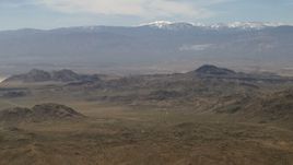 4K aerial stock footage of a view of snowy San Bernardino Mountains from Mojave Desert mountains, San Bernardino County, California Aerial Stock Footage | FG0001_000116