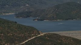4K aerial stock footage approach the lake and dam as speedboats cruise across Silverwood Lake, California Aerial Stock Footage | FG0001_000128