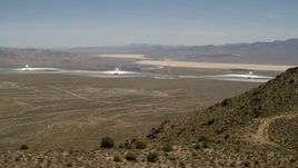 4K aerial stock footage of towers and arrays of the Ivanpah Solar Electric Generating System, California, eclipsed by mountain Aerial Stock Footage | FG0001_000165