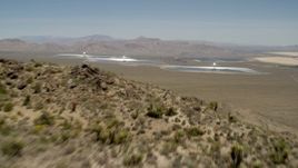 4K aerial stock footage fly over a desert mountain to reveal the Ivanpah Solar Electric Generating System in California Aerial Stock Footage | FG0001_000171