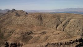 4K aerial stock footage of steep-sloped mountain ridges in the Nevada Desert and Lake Mead in the background Aerial Stock Footage | FG0001_000261