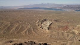 4K aerial stock footage approach a scarred hillside with Lake Mead in the background, Nevada Desert Aerial Stock Footage | FG0001_000264