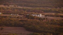 HD stock footage aerial video of large tanks on a farm at sunset in Nocona, Texas Aerial Stock Footage | HDA12_152