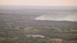 HD stock footage aerial video of smoke rising from trees at sunset and zoom to wider view, Texas Aerial Stock Footage | HDA12_168