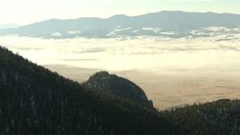 HD stock footage aerial video of a fog-shrouded valley and snowy Rocky Mountains, Park County, Colorado Aerial Stock Footage | HDA13_306
