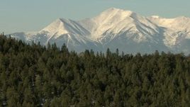 HD stock footage aerial video fly over trees-covered ridge to approach snowy Rocky Mountains, Colorado Aerial Stock Footage | HDA13_322