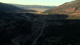 HD stock footage aerial video of following the highway at sunset toward rural homes in Ridgway, Colorado Aerial Stock Footage | HDA13_392