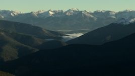 HD stock footage aerial video of fog between mountain slopes near snowy Rocky Mountains at sunrise, Colorado Aerial Stock Footage | HDA13_438_02