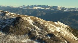 HD stock footage aerial video of a mountain summit with snow at sunrise, zoom to wider view of Rocky Mountains, Colorado Aerial Stock Footage | HDA13_450