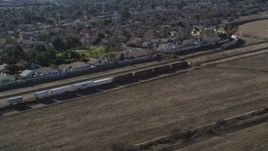 5K aerial stock footage of tracking train traveling by suburban area, fields, Pittsburg, California Aerial Stock Footage | JDC01_084