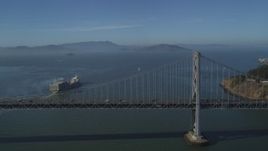 5K aerial stock footage of flying by a cargo ship sailing away from Bay Bridge, San Francisco, California Aerial Stock Footage | JDC02_043