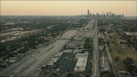 HD aerial stock footage follow freeway and rail through South Side at sunset toward Downtown Chicago, Illinois Aerial Stock Footage | PP001_020