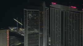 HD stock footage aerial video of flying by a hotel and casino to reveal rides on Steel Pier at night, Atlantic City, New Jersey Aerial Stock Footage | PP003_036