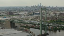 HD stock footage aerial video of a view of Downtown Philadelphia skyline, seen while passing piers and Walt Whitman Bridge, Pennsylvania Aerial Stock Footage | PP003_090