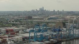 HD stock footage aerial video of containers and cranes at a shipping port, with a view of Downtown Philadelphia skyline, Pennsylvania Aerial Stock Footage | PP003_091