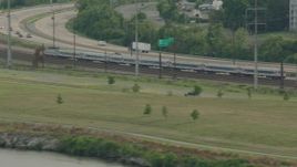 HD stock footage aerial video of a commuter train by a freeway in Wilmington, Delaware Aerial Stock Footage | PP003_107