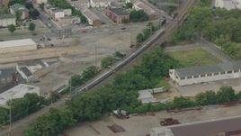 HD stock footage aerial video track a commuter train passing industrial buildings in Wilmington, Delaware Aerial Stock Footage | PP003_114