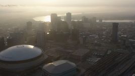 4K aerial stock footage tilt to reveal Superdome and Downtown New Orleans skyscrapers at sunrise, Louisiana Aerial Stock Footage | PVED01_009