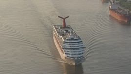 4K aerial stock footage of Carnival Cruise ship sailing Mississippi River, reveal Downtown New Orleans at sunrise, Louisiana Aerial Stock Footage | PVED01_012E