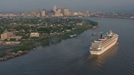 4K aerial stock footage of a Carnival Cruise ship sailing the Mississippi River near Downtown New Orleans, Louisiana at sunrise Aerial Stock Footage | PVED01_014
