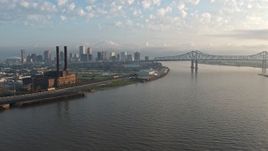 4K aerial stock footage of Downtown New Orleans and Crescent City Connection seen from the river at sunrise, Louisiana Aerial Stock Footage | PVED01_019