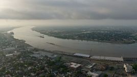 4K aerial stock footage of a wide orbit of barges on the Mississippi River by the French Quarter of New Orleans at sunrise, Louisiana Aerial Stock Footage | PVED01_057
