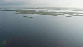 4K aerial stock footage fly over patches of bayou marshland at sunrise in St. Bernard Parish and reveal surge barrier, Louisiana Aerial Stock Footage | PVED01_074E