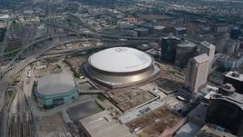 4K aerial stock footage slow orbit of the Superdome and New Orleans Arena in Downtown New Orleans, Louisiana Aerial Stock Footage | PVED01_124