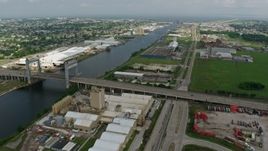 4K aerial stock footage flyby small bridge and factory buildings on the shore of Industrial Canal in New Orleans East, Louisiana Aerial Stock Footage | PVED01_168