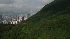5K stock footage aerial video fly over forest mountain and tilt to reveal skyscrapers on Hong Kong Island, China Aerial Stock Footage | SS01_0034